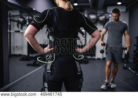 A Cropped Portrait Of A Woman In A Black Ems Training Suit Standing In The Middle Of The Training Ce
