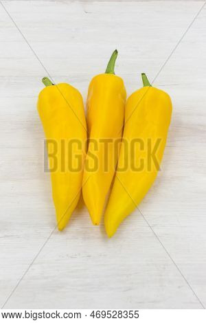 Yellow Sweet Pepper Ramiro Is Lying On A White Wooden Table