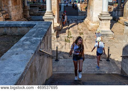 Antalya, Turkey - July 08, 2018: Unknown Young Woman Near The Historical Roman Hadrian Gate In Kalei