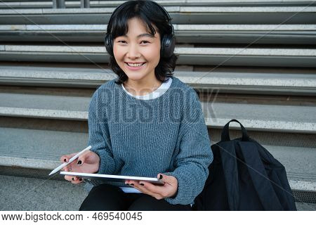 Young Asian Girl, Student In Headphones, Works On Remote, Digital Artist Drawing On Tablet With Grap