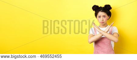 Sad Girl Begging To Stop, Frowning Uspet And Showing Cross Sign, Say No, Standing Gloomy On Yellow B