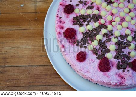 Rasperry Cake With Cream And White Chocolate On Wooden Board