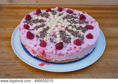Rasperry Cake With Cream And White Chocolate On Wooden Board