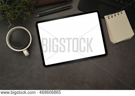 Digital Tablet With Blank Display, Cup Of Coffee And Notepad On Black Slate Texture Background