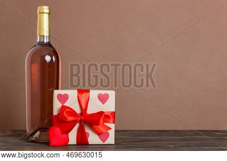 Bottle Of Wine On Colored Background For Valentine Day With Gift Box. Heart Shaped With Presrnt Box 