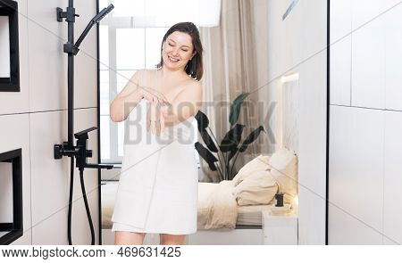 Smiling Woman Check Water Temperature In The Shower With Hand Shower Wall.