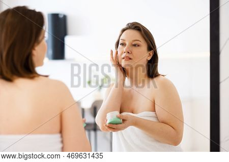 Adult Woman Apply Body Cream Look In Mirror At Home. Beauty And Lifestyle Concept.
