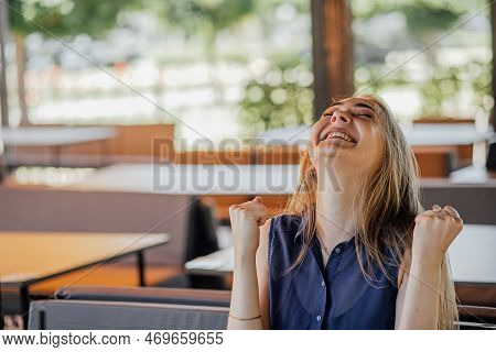 A Girl Sits On A Summer Terrace And Works At A Laptop. Freelance. Selfeducation. The Concept Of Remo