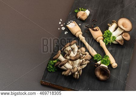 Delicious Organic Oyster Mushrooms With Spices And Fresh Parsley On Wooden Cutting Board