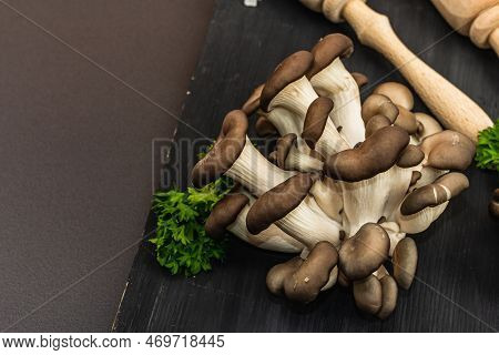 Delicious Organic Oyster Mushrooms With Spices And Fresh Parsley On Wooden Cutting Board