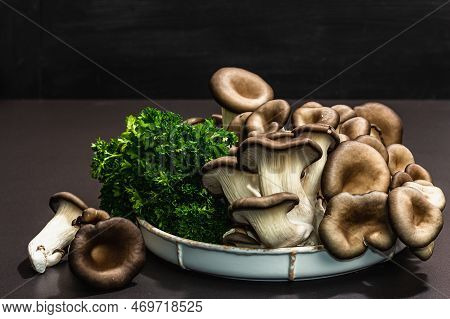 Delicious Organic Oyster Mushrooms With Fresh Parsley. Source Of Beta Glucan, Black Stone Background