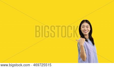 Asian woman pointing finger inviting click here, It is recommended to follow this direction or click