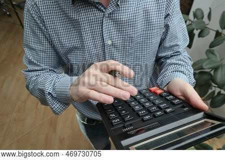 Man Using A Calc For Financial Estimation. Necessary Calculations. Male Businessman Hand Pushing Key