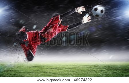 Torwart fängt den Ball. Im Stadion, im Rampenlicht.