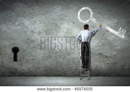 키를 잡고 사다리에 서 서 사업가의 이미지