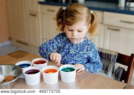 Excited Little Toddler Girl Coloring Eggs For Easter. Cute Happy Child Looking Surprised At Colorful