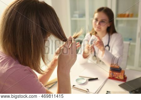 Doctor Offering Medicine For Split Ends To Woman Patient In Clinic. Pharmacological Products For Hai