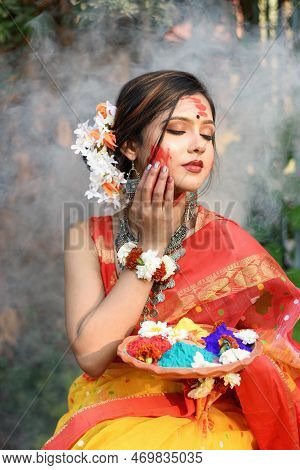 Portrait Of Pretty Young Indian Girl Wearing Traditional Saree And Jewellery, Holding Powder Colours