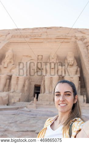 Vertical Selfie Viewof Young Beautiful Smiling Tourist Woman With Abu Simbel Temple In The Backgroun