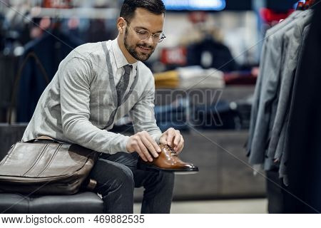 An Elegant Man Is Trying Out New Shows In A Butique.