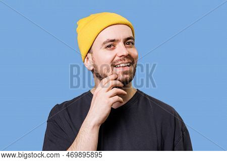 A Man With A Contemplative Look On His Face Sits Against A Blue Background, As If Hes Thinking Deepl