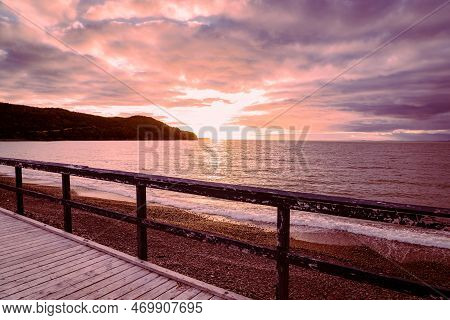Wooden Boardwalk With Handrail Overlooking The Atlantic Ocean During Sunset At Placentia Newfoundlan