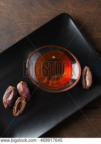 Natural Organic Healthy Date Syrup In A Glass Bowl With Whole Dates On The Background. Top View