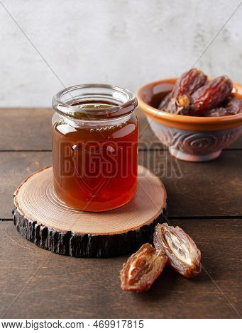 Natural Organic Healthy Date Syrup In A Glass Jar With Whole Dates On The Background