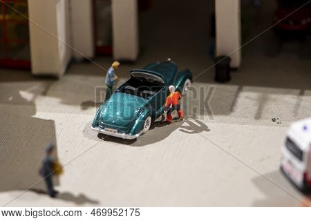 A Miniature Scene, A Man Drove His Convertible To The Garage, The Mechanic Of The Car Center Inspect