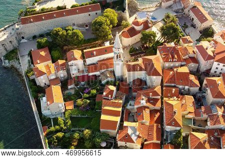 Panoramic Sunset Aerial Drone View Of Ancient City Of Budva, Montenegro. Old Medieval Town With Red 