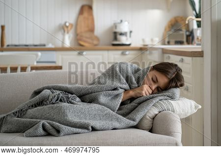 Sick Girl Child Covered With Blanket Lying On Sofa At Home Coughing, Having Flu Symptoms. Ill Kid Wi