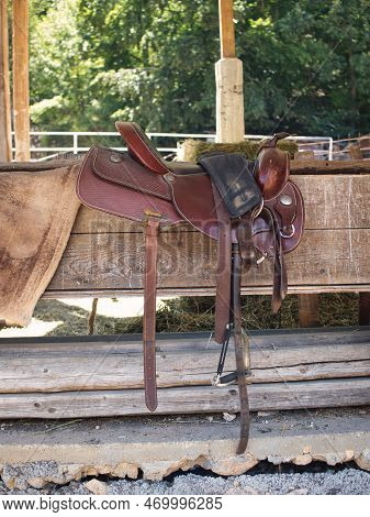 The Saddle Is Brown On The Fence In A Shallow Depth Of Field. Leather Saddle, Harness For Horses. We