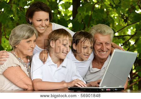 Family with laptop in nature
