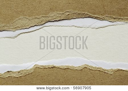 Hole ripped in brown paper on white background