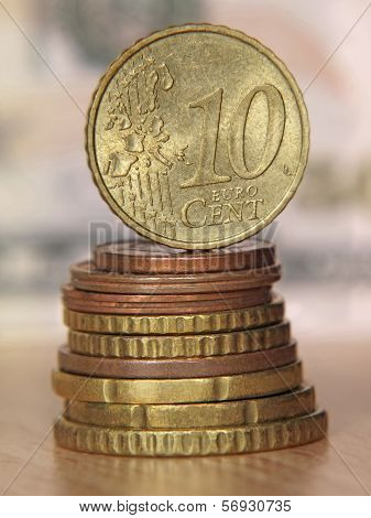 Ten Euro Cent Coin Balancing On A Top Of Coins Stack.