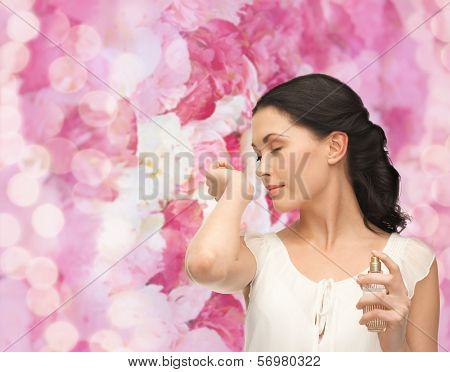 picture of beautiful woman smelling pefrume on her hand