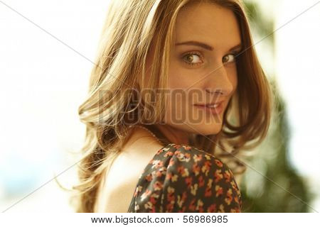 Close-up shot of a gorgeous beauty with curly hair and flirty look