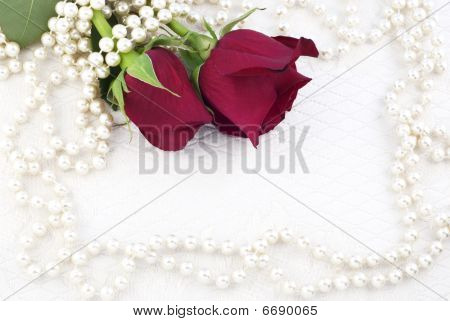 Dos rosas rojas y perlas