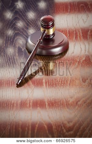 Wooden Gavel Resting on American Flag Reflecting Table.
