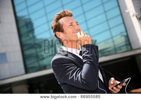 Businessman talking on phone outside building