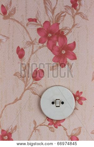 an old wallpaper with light switch. symbolic photo for renovation and remodel.