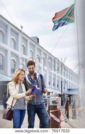 South Africa tourism couple with guide book on vacation holiday