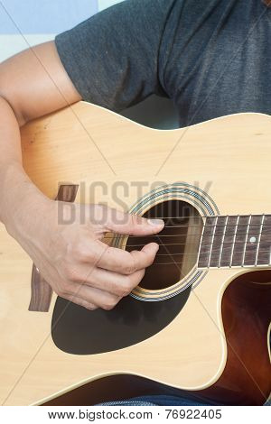Guitarist playing folk songs with old guitar