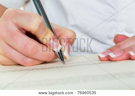 a woman signs a contract or a will with a fountain pen.
