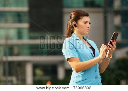 Business Woman Making A Phone Call With Bluetooth Device