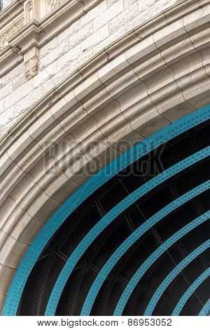 A close-up view of a blue steel and stone arch
