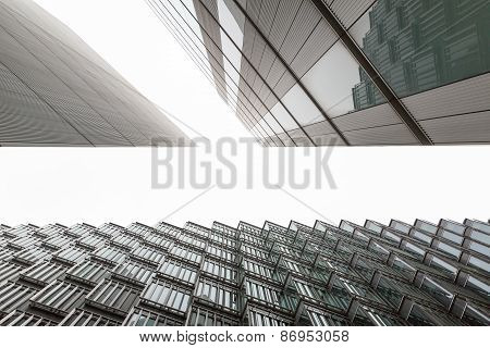 A photo looking up capturing three different buildings on an angle