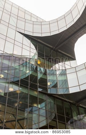 A detail of a building with curves using glass material as cladding