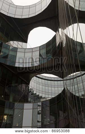 A close-up of looking up of a curved facade building made in glass