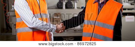 Workers In Factory Shake Hands